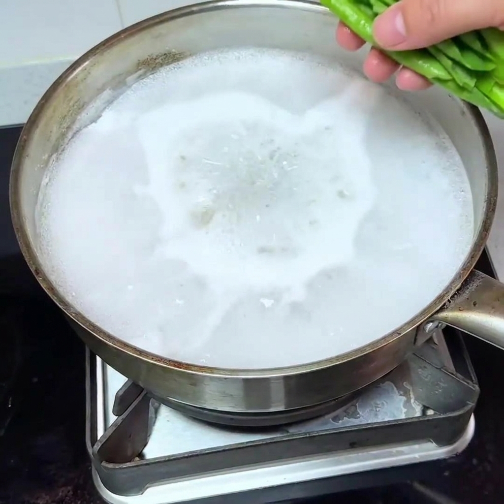 Bok choy fresco añadido a una olla de agua hirviendo.