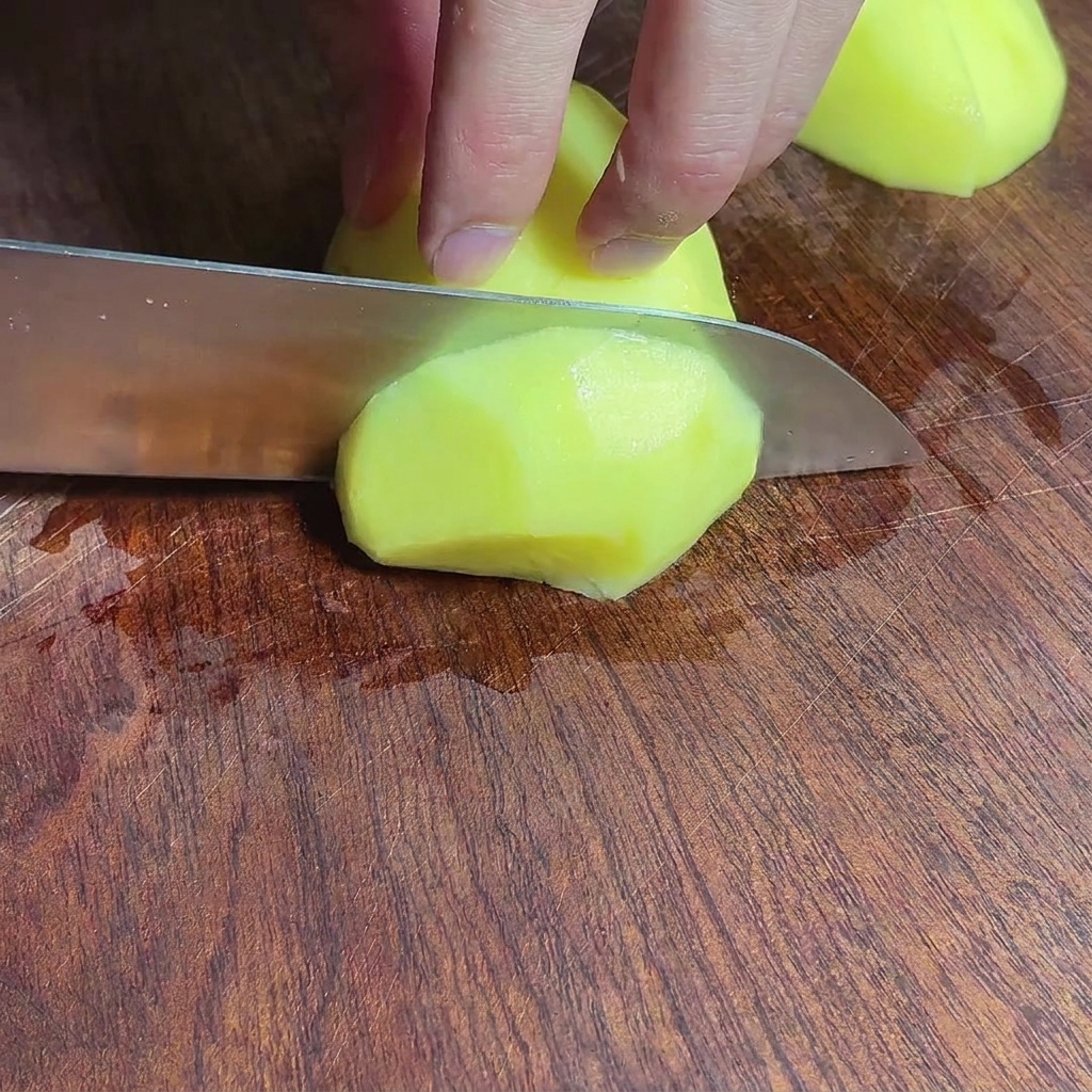 Trozos de patata picados en una tabla de cortar de madera.
