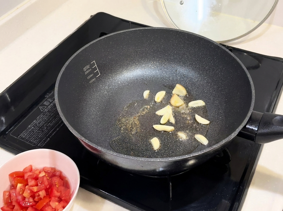 Láminas de ajo dorándose en una sartén caliente con aceite.
