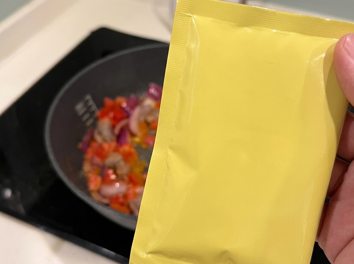 Vino para cocinar siendo vertido sobre la mezcla de ternera, tomates y cebolla.