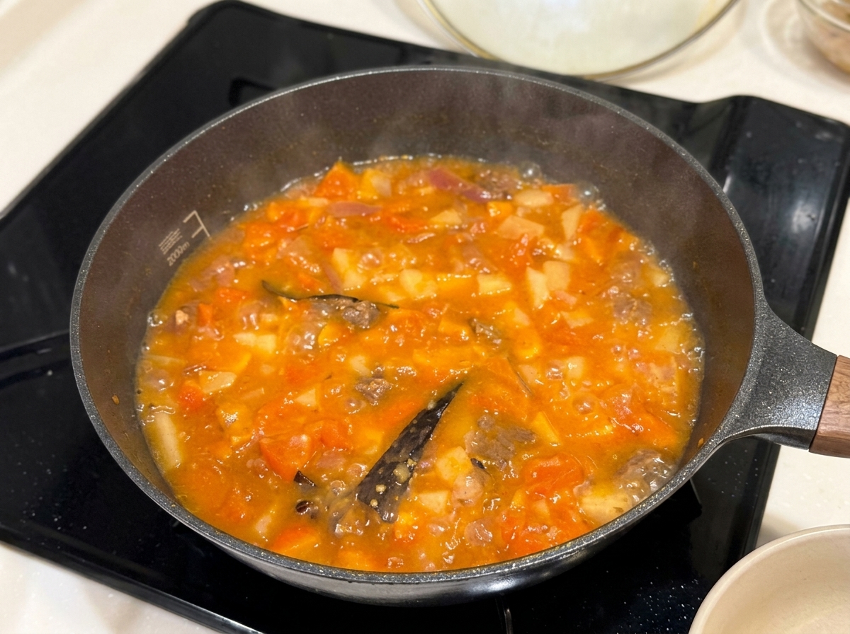 Bloques de curry siendo colocados en el estofado a fuego lento.