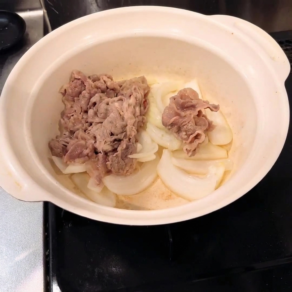 Ternera escaldada mezclada con cebollas dentro de una olla.