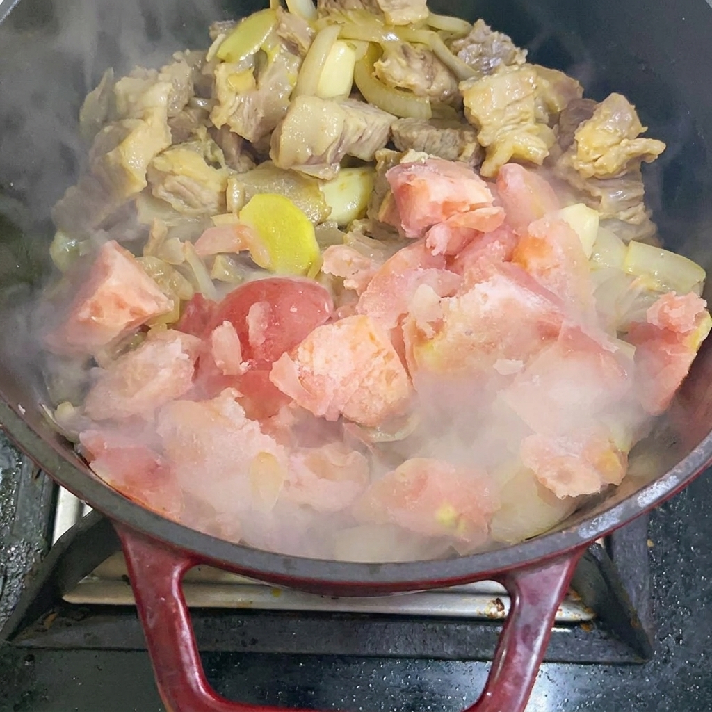 Añadiendo trozos de tomate congelado al salteado.