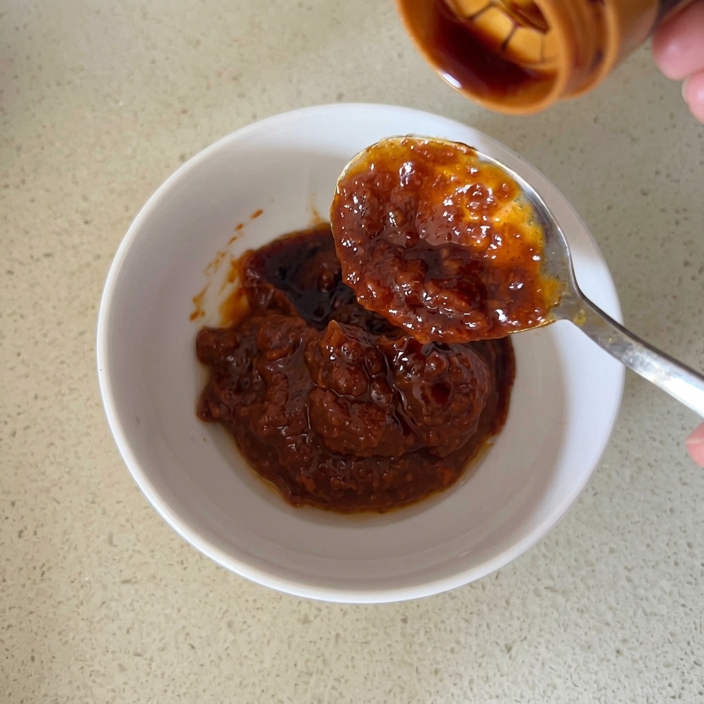 Primer plano de los ingredientes de la salsa siendo mezclados en un tazón.