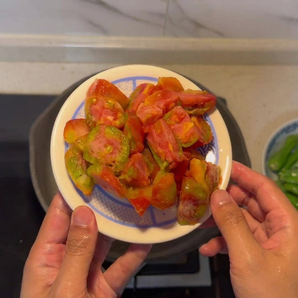 Un plato con tomates pelados y troceados listos para cocinar.