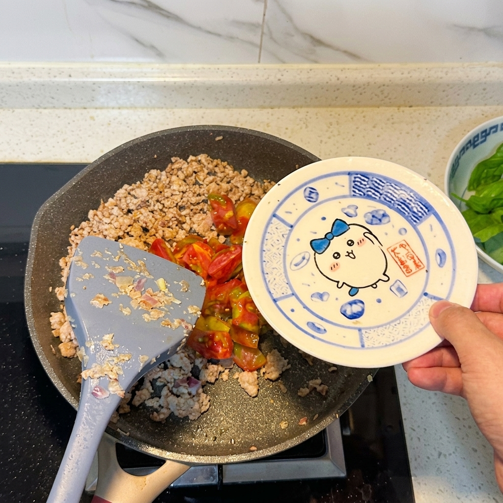 Tomates troceados siendo añadidos a la sartén con la carne.