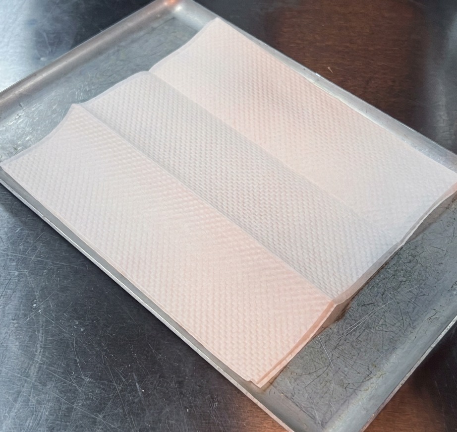 Primer plano de un bistec frito dorado sobre una toalla de papel absorbente.