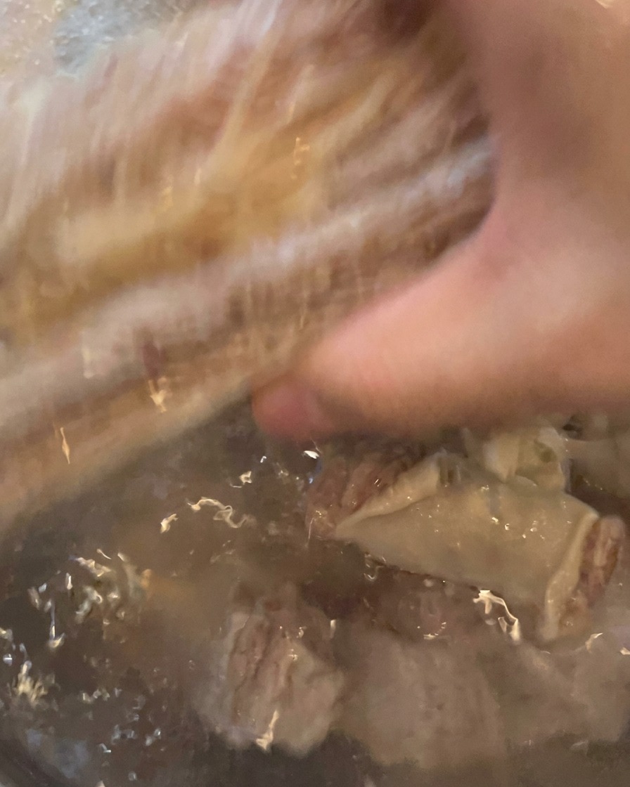 Costillas siendo enjuagadas bajo el grifo de agua, viéndose limpias y listas para la olla.