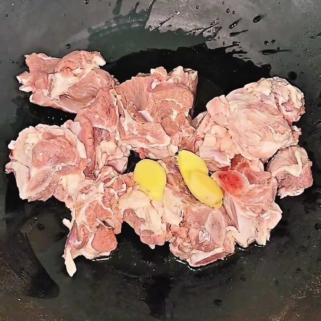 Costillas de res hirviendo a fuego lento en una olla con rodajas de jengibre y vino de cocina durante el proceso de blanqueado.