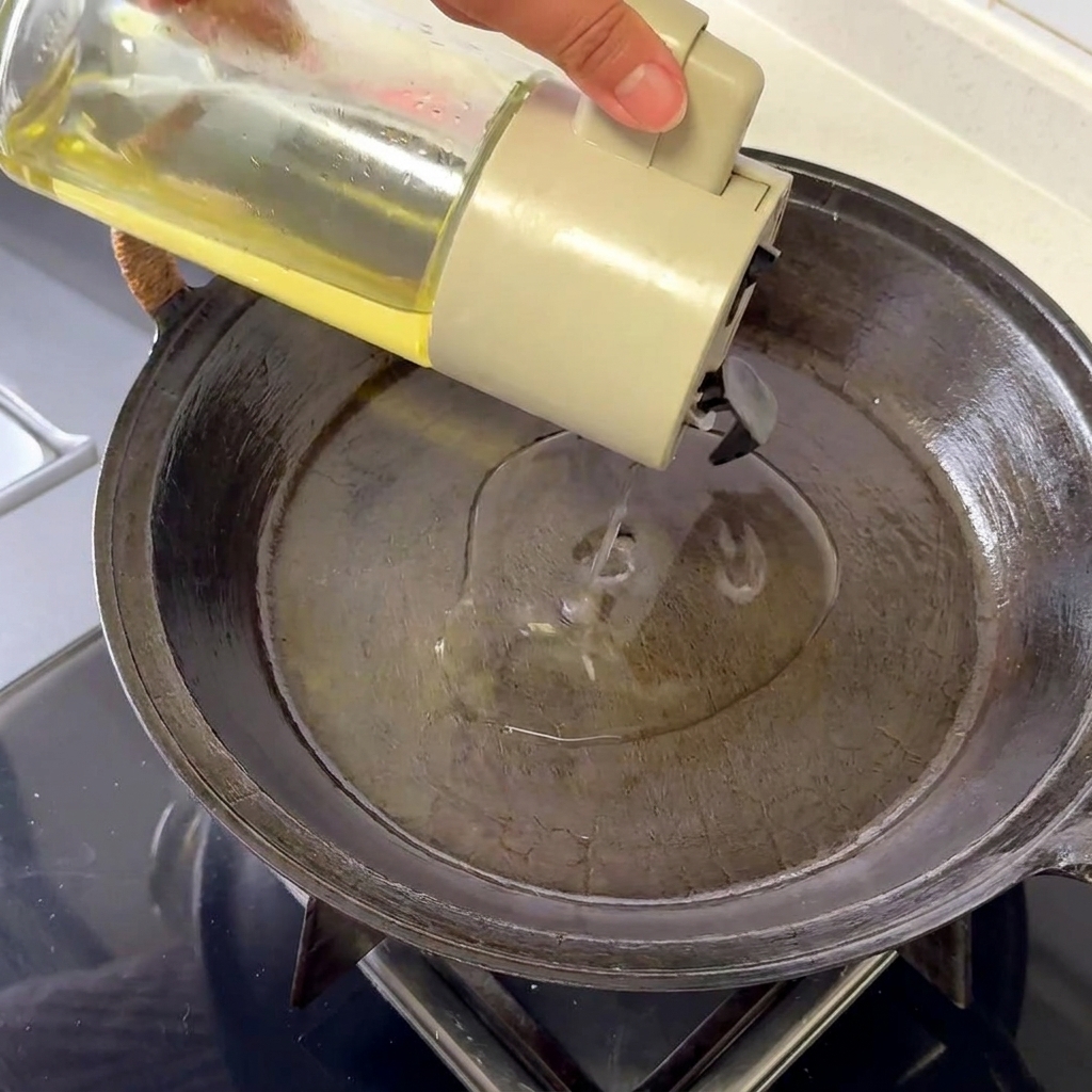 Un solo huevo friéndose en una sartén caliente, mostrando claras burbujeantes y bordes dorados y crujientes.