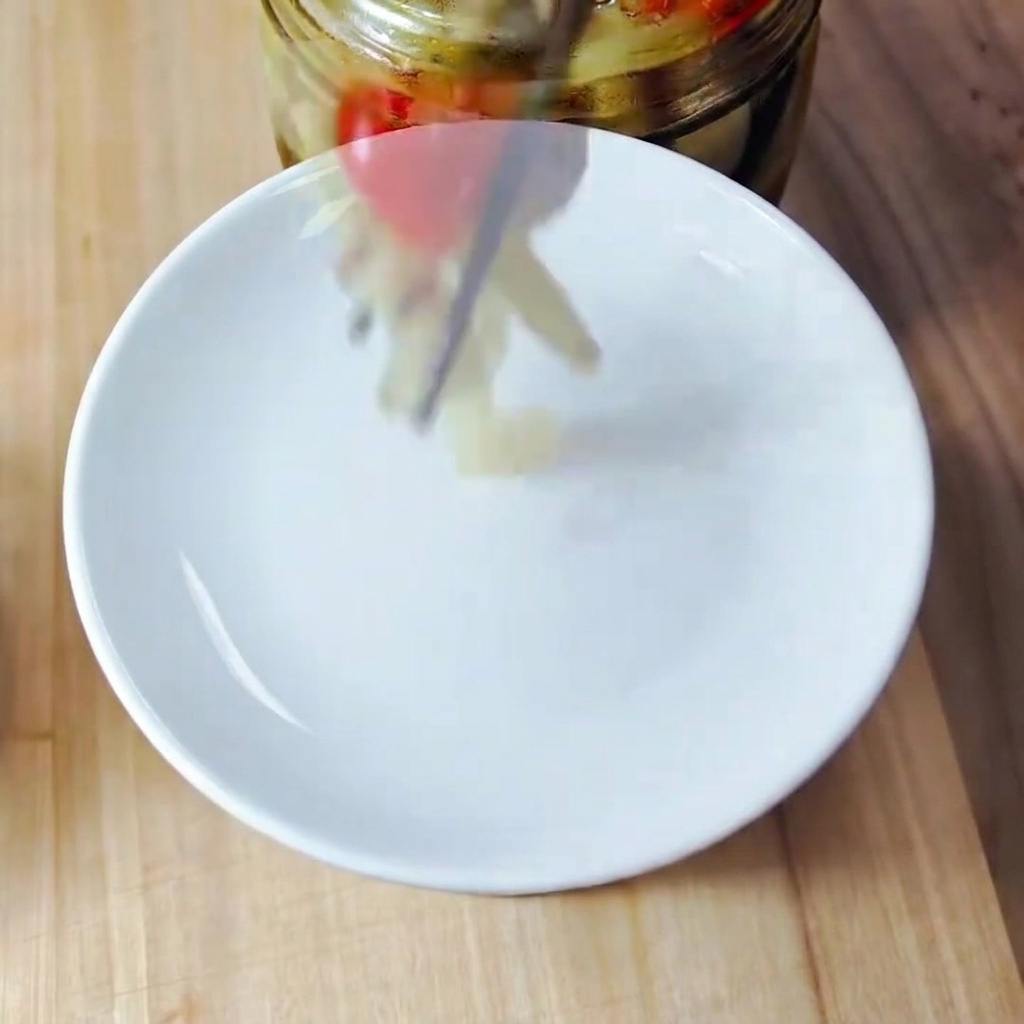 Trozos de kimchi finamente picados sobre una tabla de cortar de madera.