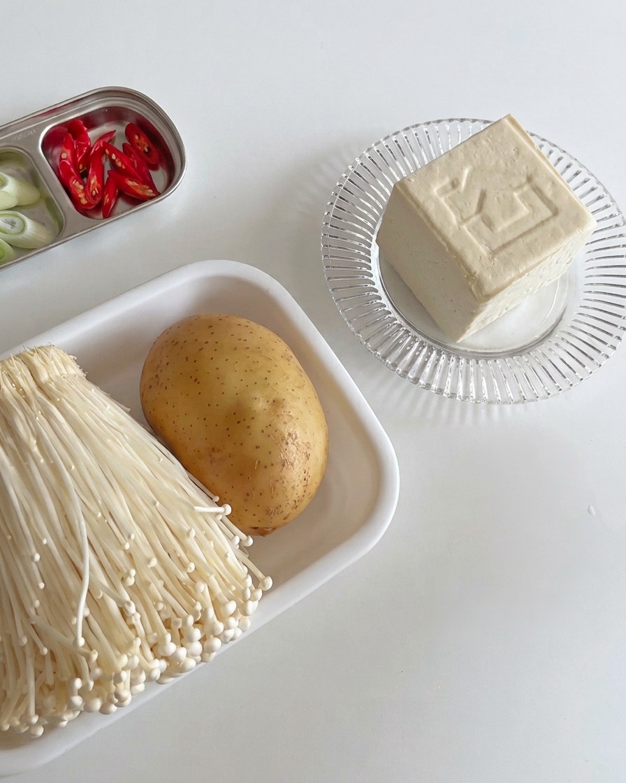 Bloques de tofu blanco firme cortados en rodajas gruesas y ordenadas sobre una tabla de madera, listos para cocinar.