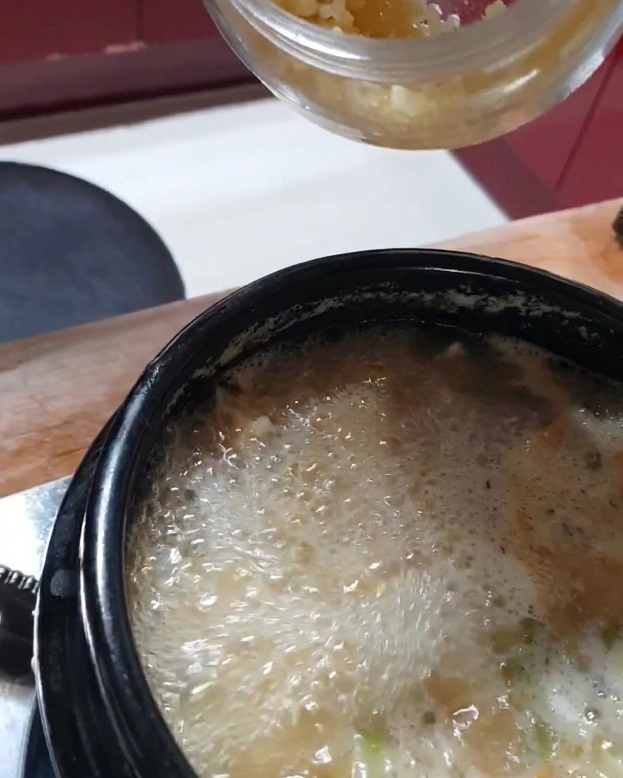Una cucharada de ajo picado fresco siendo añadida al estofado.