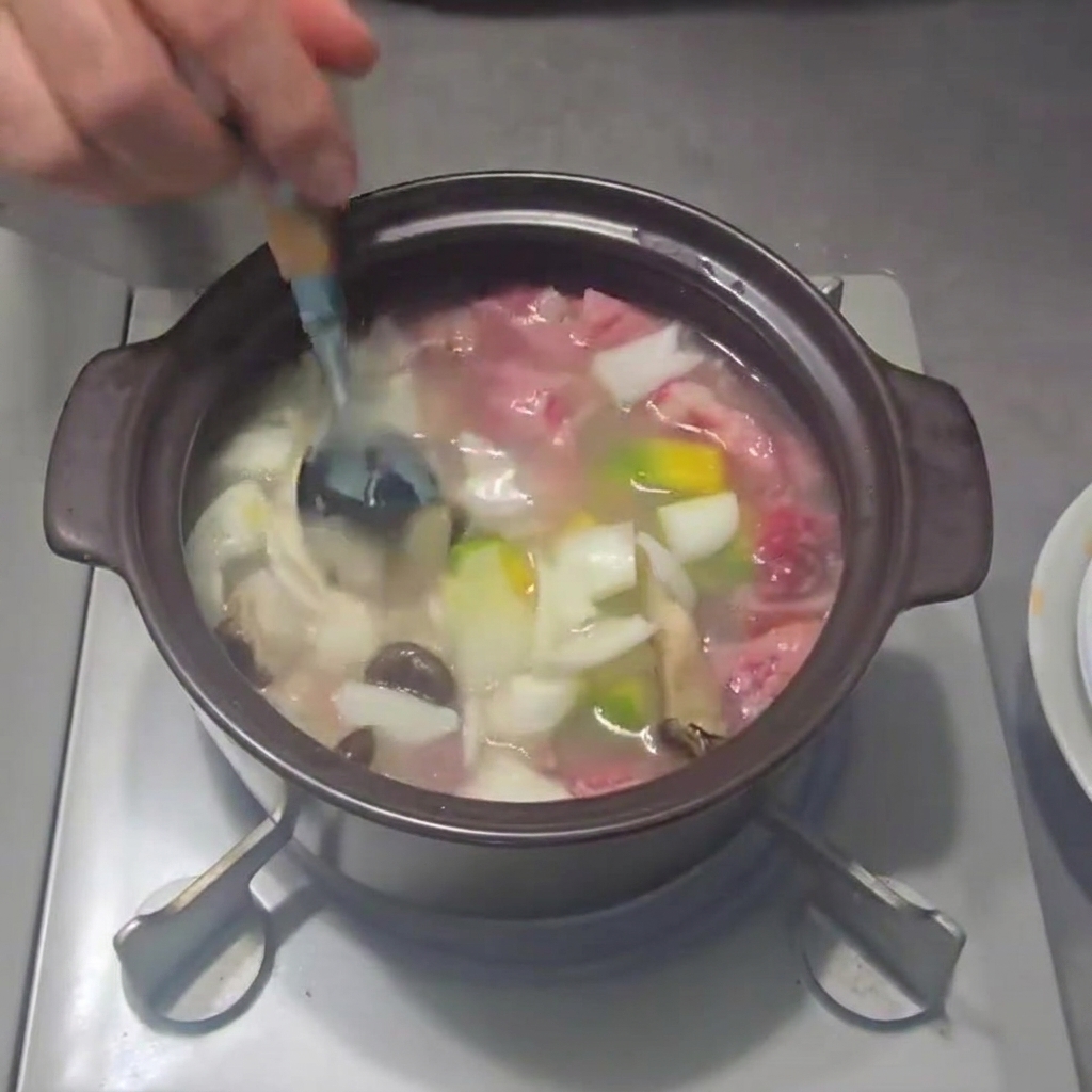 Cebolletas picadas siendo espolvoreadas en el estofado.