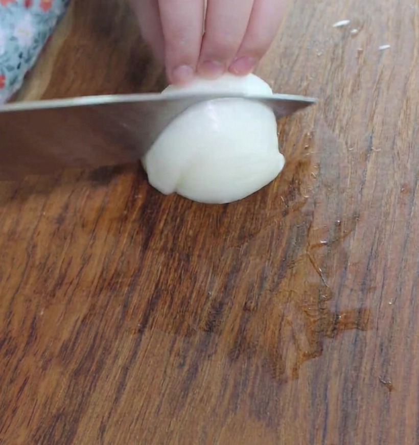 Trozos pequeños de cebolla picada sobre una tabla de cortar.