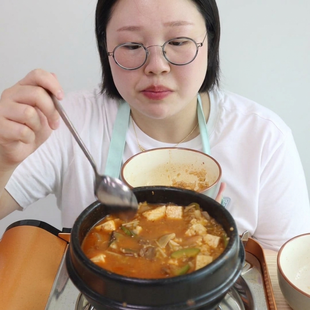 Arroz blanco cocido siendo mezclado en el estofado espeso y burbujeante.