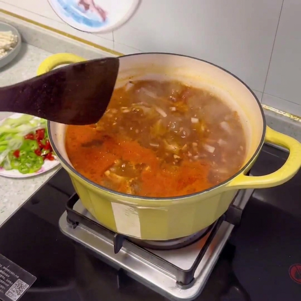 Diferentes verduras en rodajas y almejas añadiéndose a la olla del estofado de ternera.