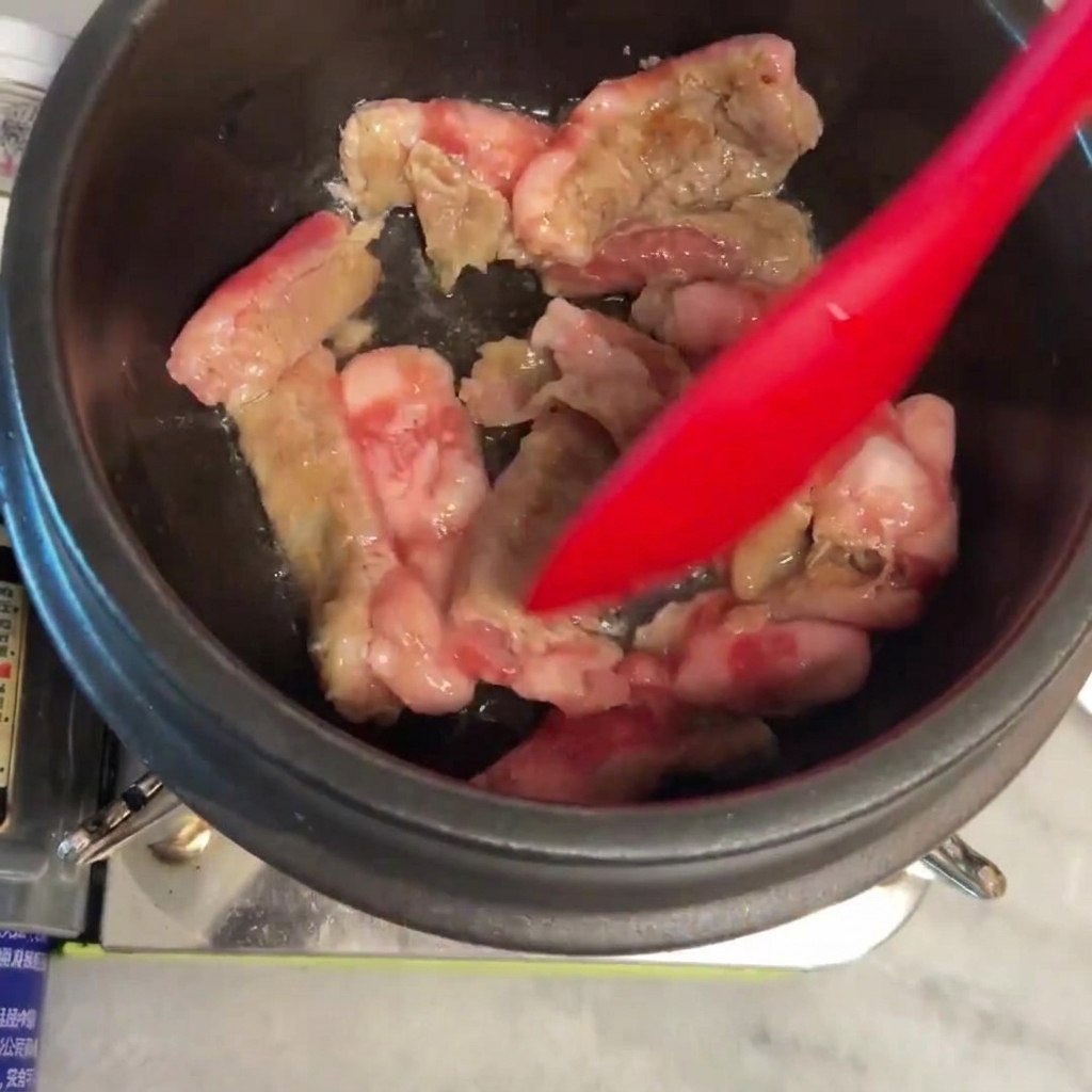 Carne siendo salteada y dorada en la olla de piedra.