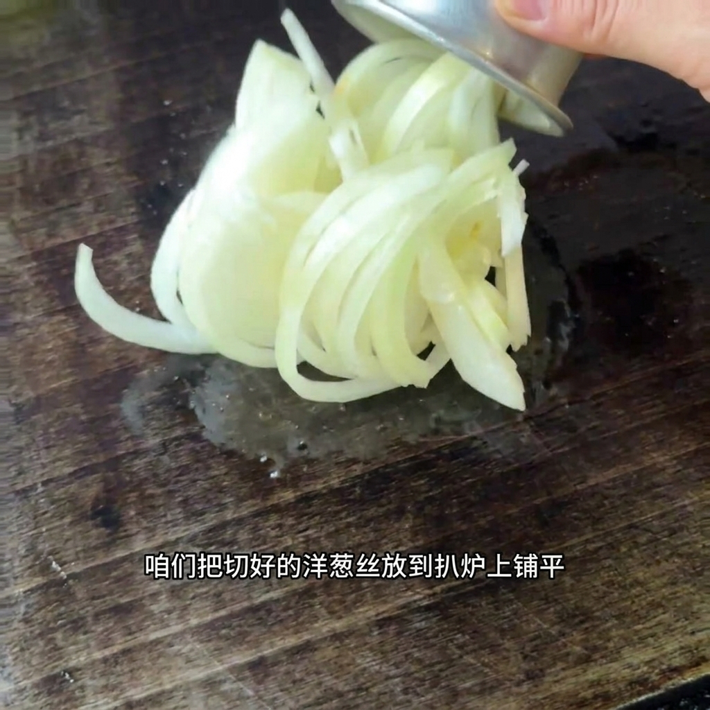 Cebollas recién cortadas extendiéndose sobre la superficie de una plancha caliente.