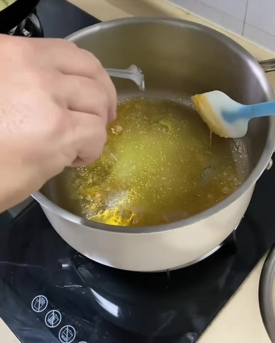 Cebollas cortadas siendo añadidas a la sartén con la mezcla de azúcar caramelizada y especias.