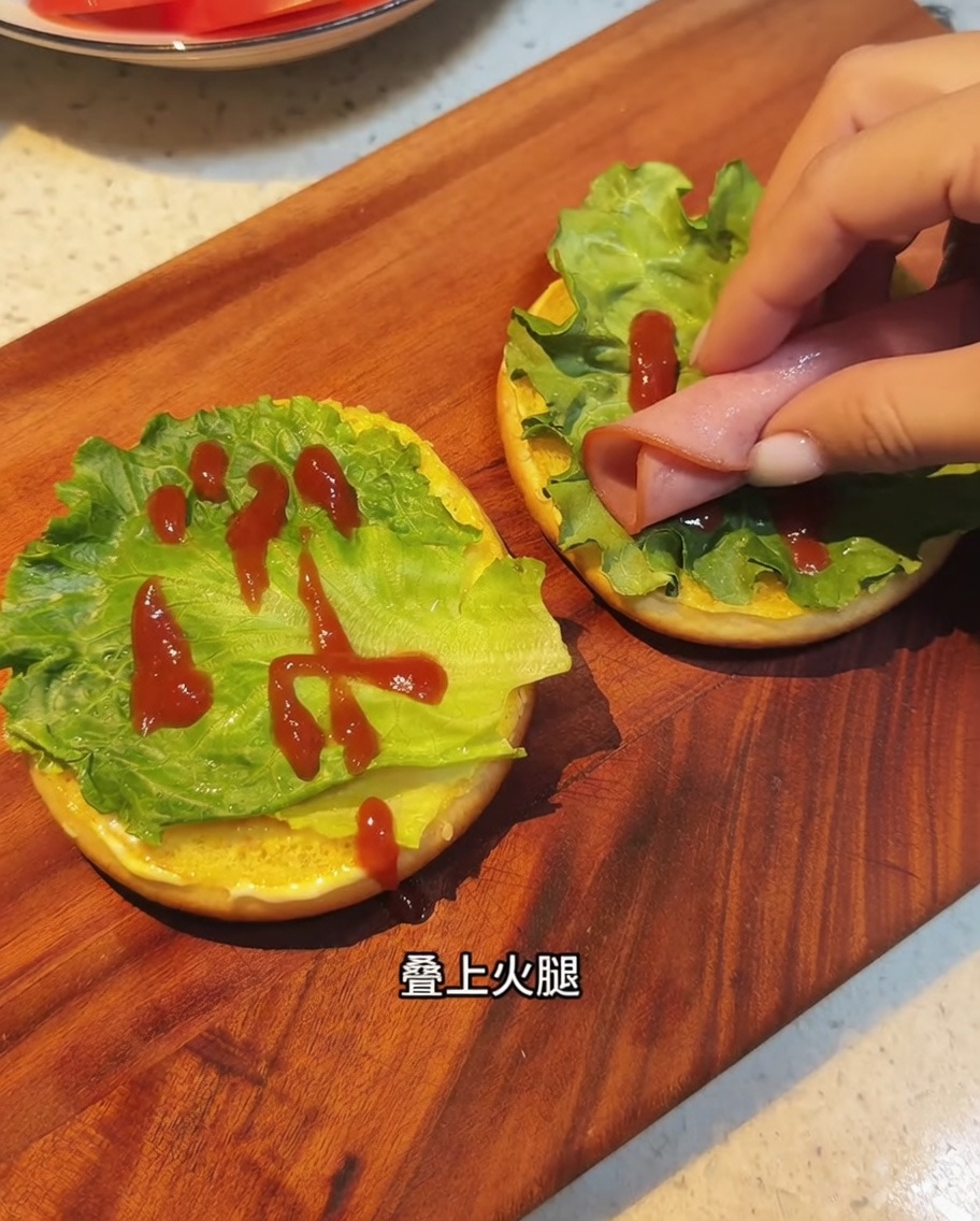 Lonchas de bacon frito siendo colocadas sobre la lechuga y la salsa.