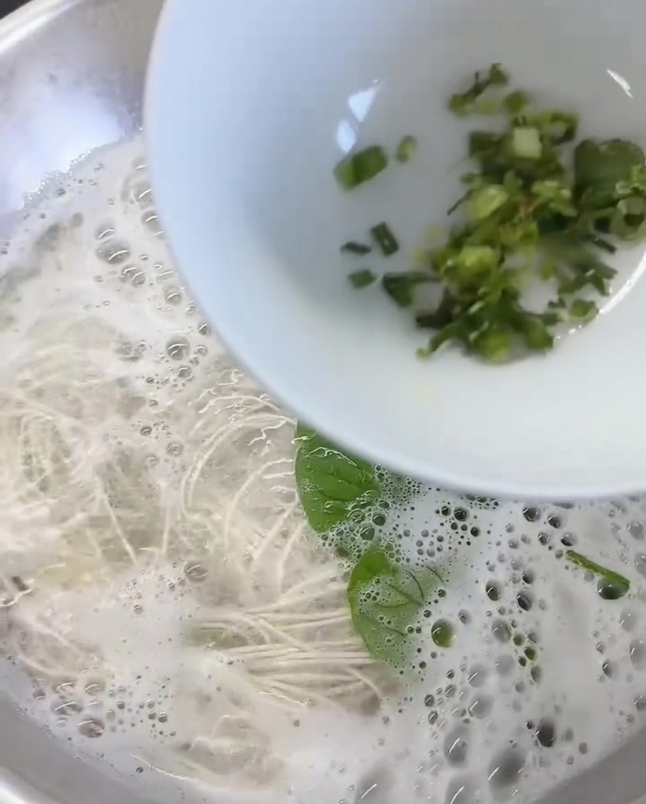 Jengibre picado y cilantro fresco en el fondo de un tazón blanco.