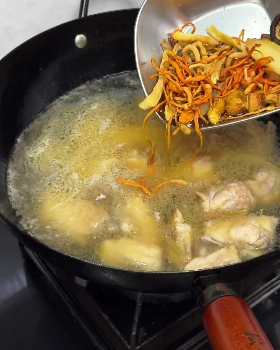 Añadiendo setas previamente hidratadas al caldo de pollo.