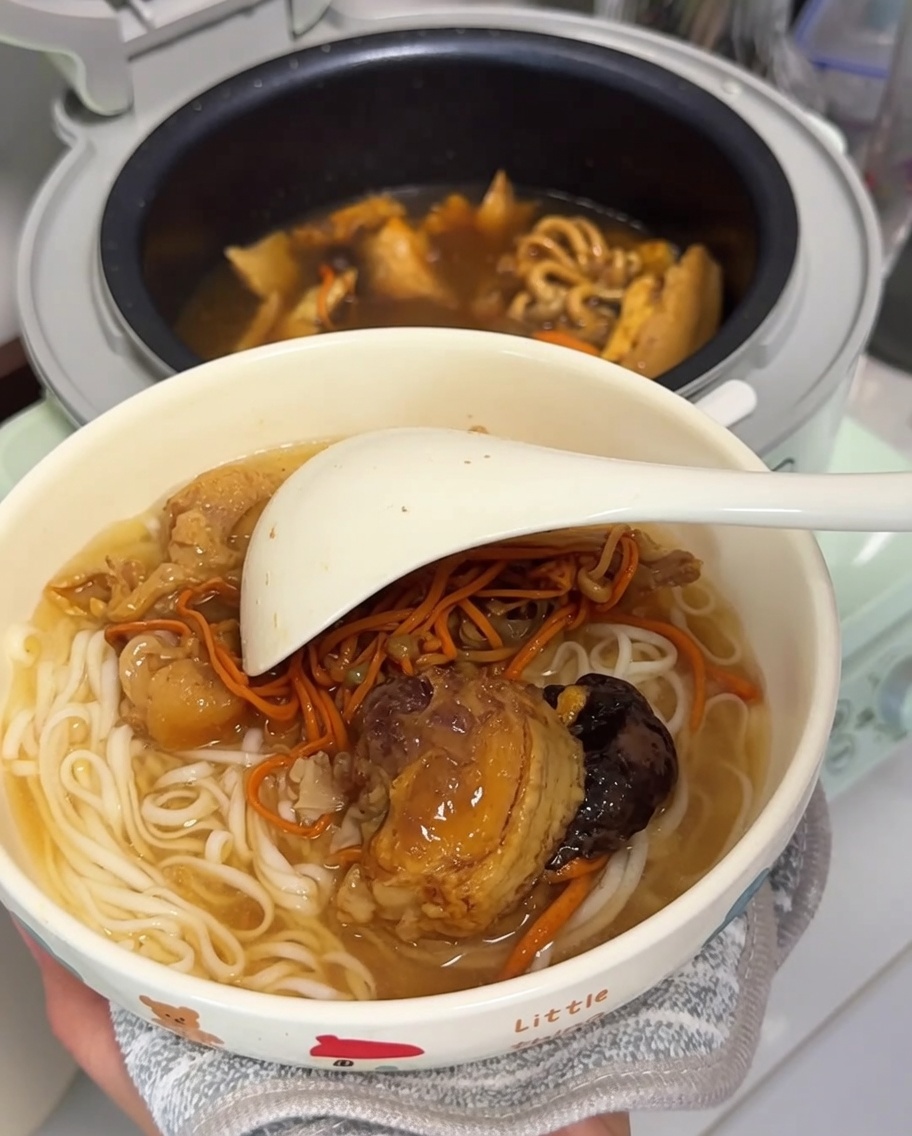 Un tazón con fideos, pollo y setas, listo para servir.
