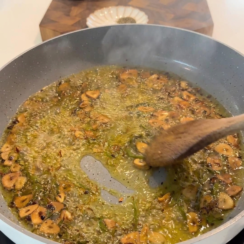 Jugo de limón fresco siendo exprimido en la sartén con ajo chisporroteante y hierbas.