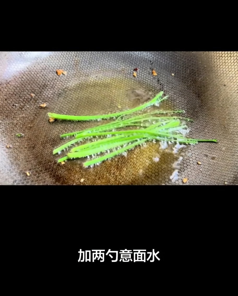 Agua de cocción de la pasta siendo vertida en el wok caliente, creando una base burbujeante.