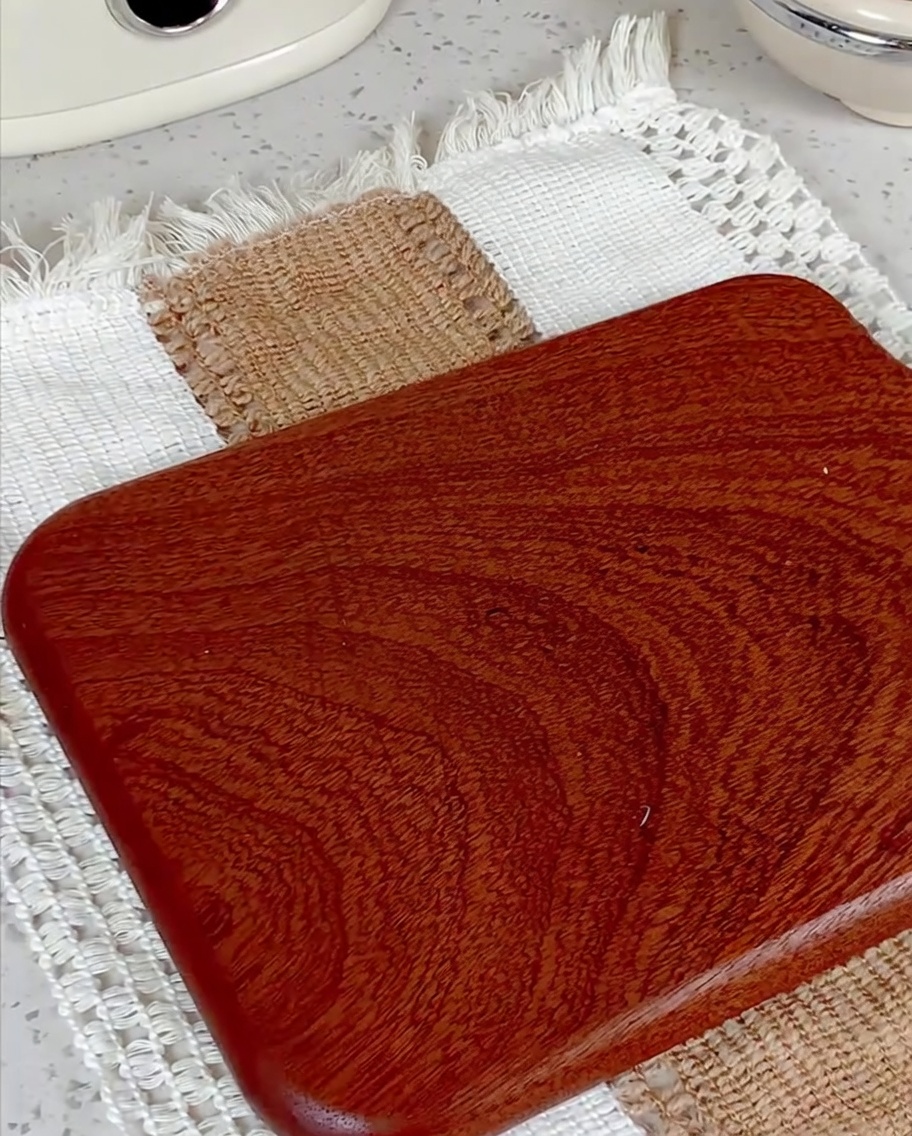 Salchicha siendo cortada en rodajas pequeñas sobre una tabla de madera.