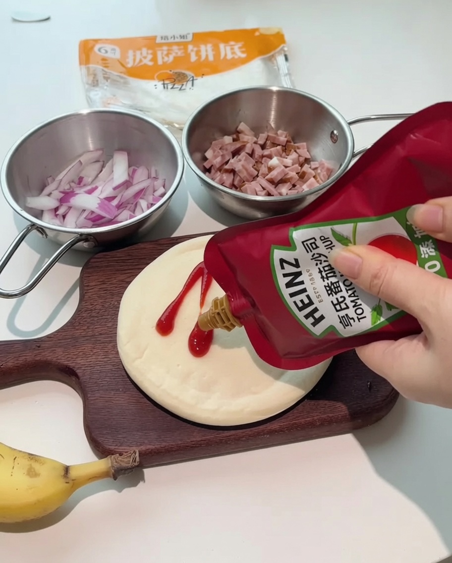 Botellas de kétchup y aliño de ensalada siendo vertidas sobre una base de pizza circular en una tabla de madera.