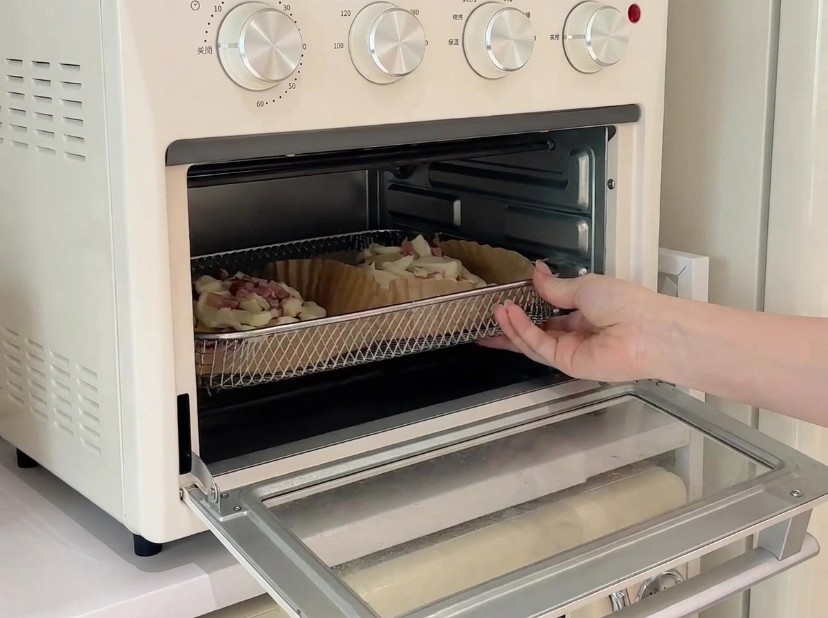 Dos mini pizzas en una rejilla dentro de un horno pequeño de encimera, horneándose.