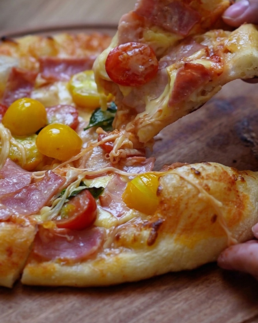 Manos presionando la masa de pizza para formar el centro fino y el borde grueso.