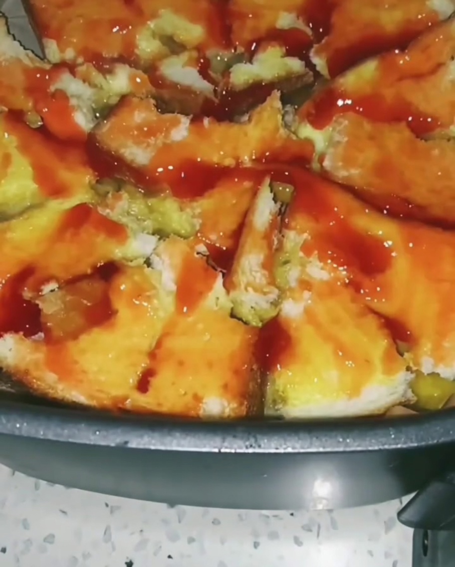 Verduras mixtas coloridas como maíz y guisantes espolvoreadas sobre la base de pan cubierta de salsa de tomate.