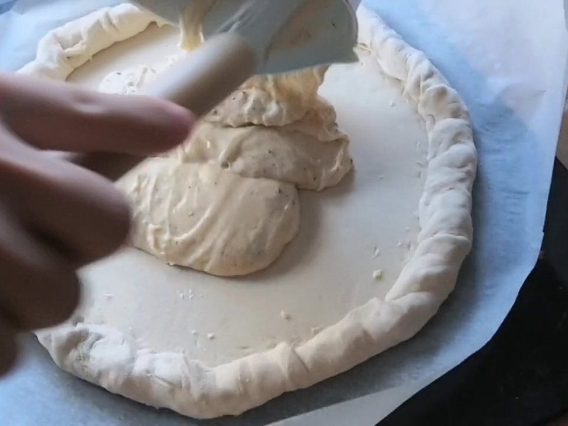 Rodajas de pepperoni y salami dispuestas sobre una masa de pizza cubierta con salsa.
