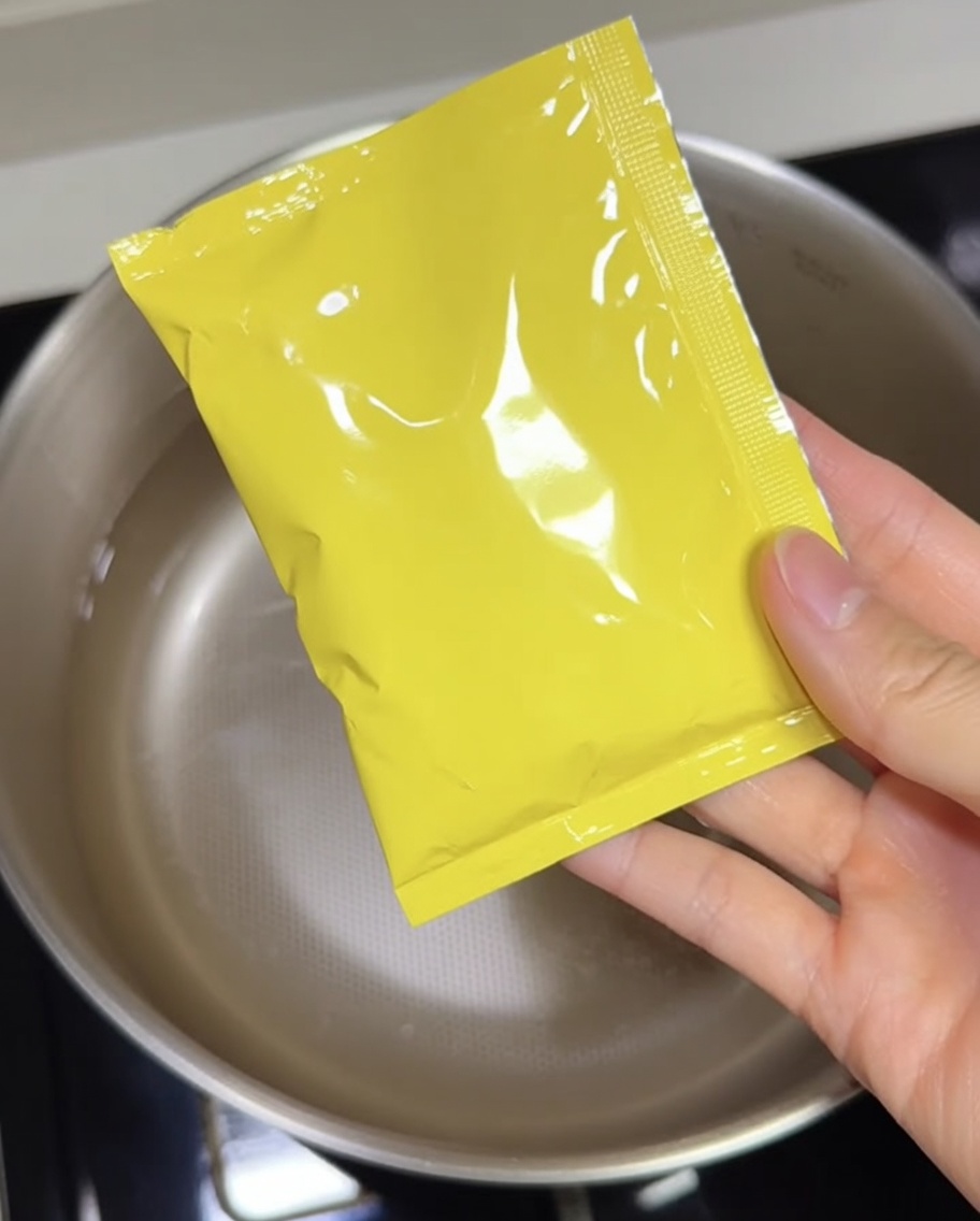 El concentrado de base de sopa tonkotsu siendo vertido en una olla.