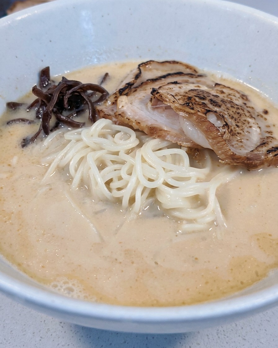 Hongos oreja de madera y brotes de bambú organizándose en el tazón de ramen.