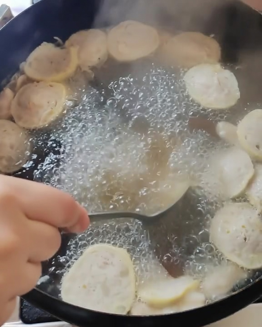 Removiendo la sopa en la olla principal después de condimentarla.