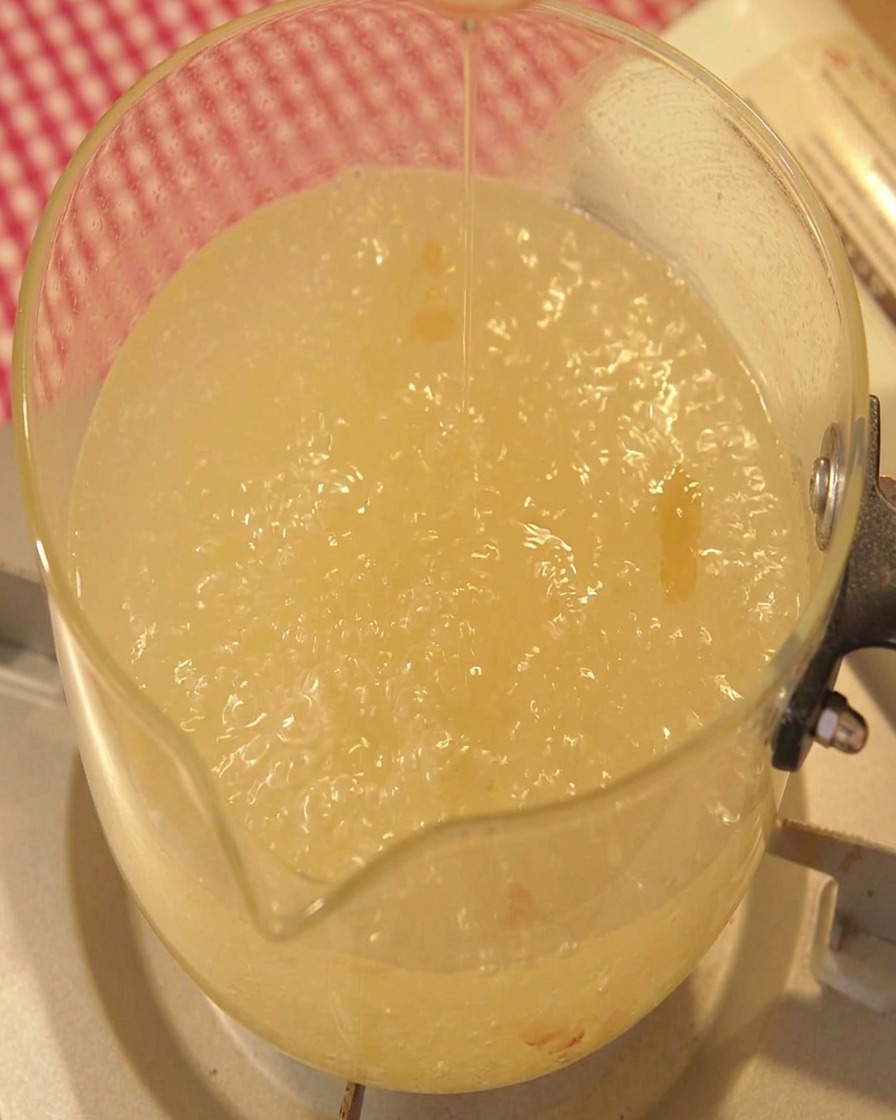 Aceite de sésamo vertiéndose en una olla con caldo hirviendo.