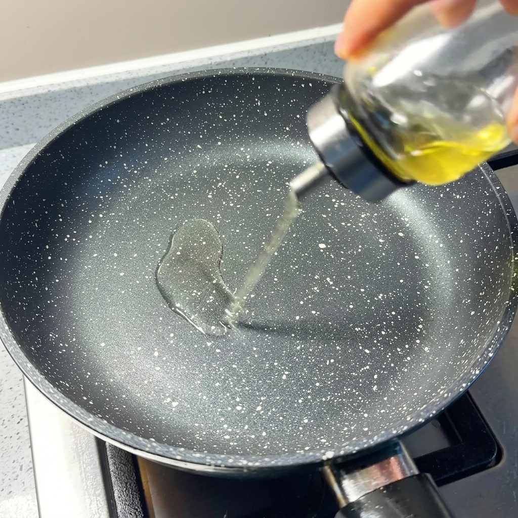 Primer plano de aceite de cocina vertido en una sartén antiadherente precalentada.