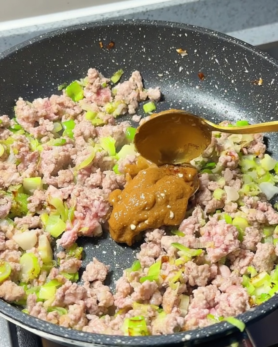 Cucharada de pasta de miso añadida a la carne cocinada.