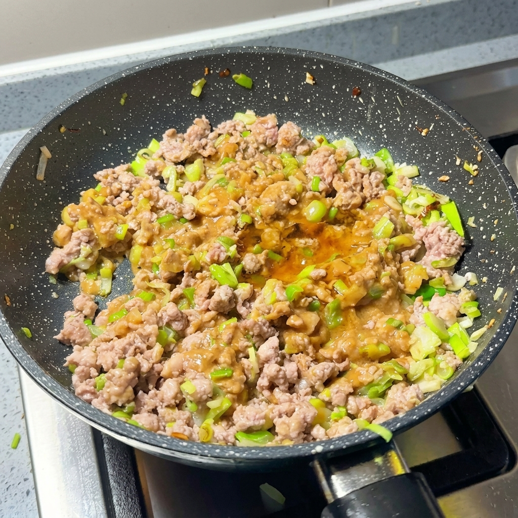 Carne y miso siendo sazonados con chile en polvo y azúcar.