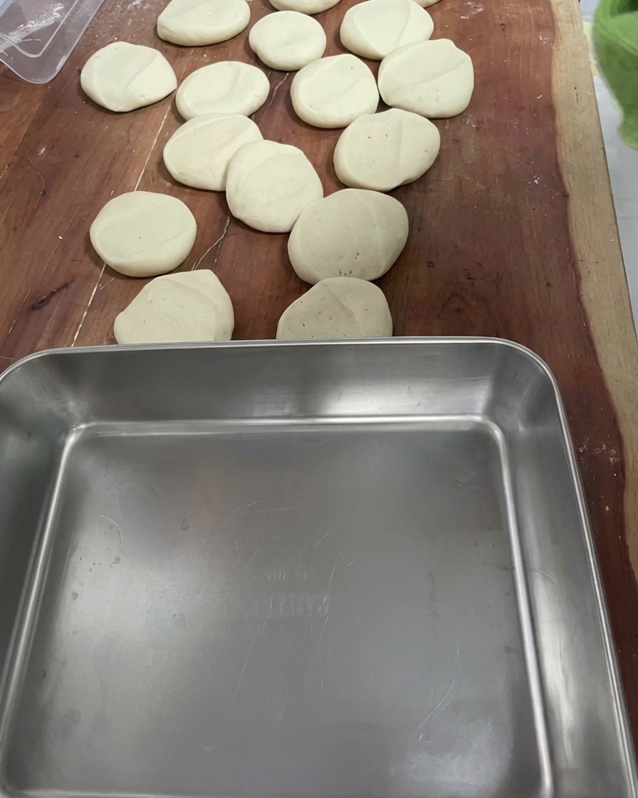 Pequeños trozos de masa uniformes sobre una superficie de madera.