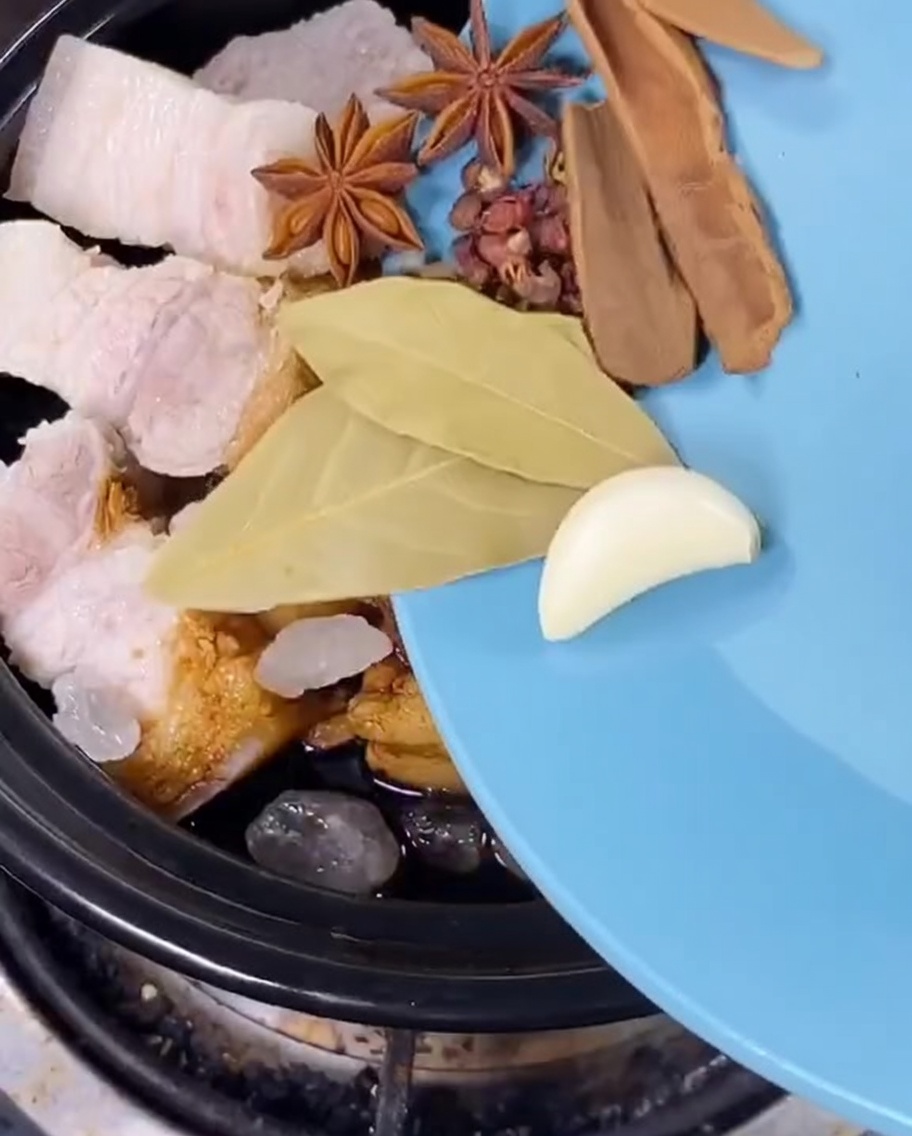 Anís estrellado, hojas de laurel, piel de cítricos y cebollinos añadidos a la olla.