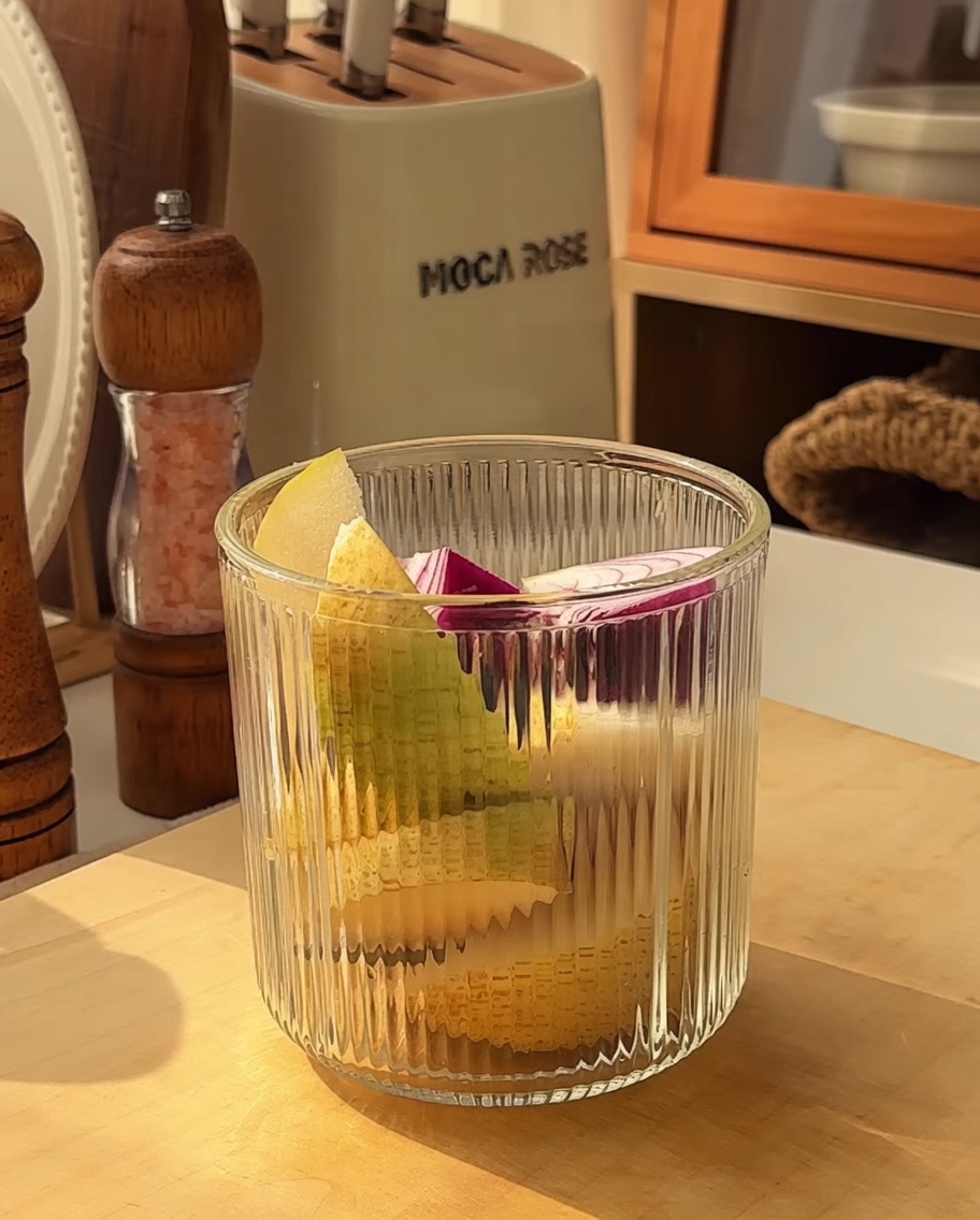 Vaso de licuadora con trozos de manzana, pera, cebolla y ajo listos para procesar.