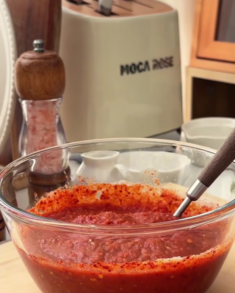 Primer plano de los ingredientes del marinado picante siendo mezclados en un bol de cristal.