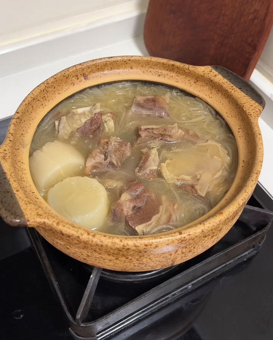 Recipiente con sopa, decorado con tiras de huevo y cebolleta fresca.