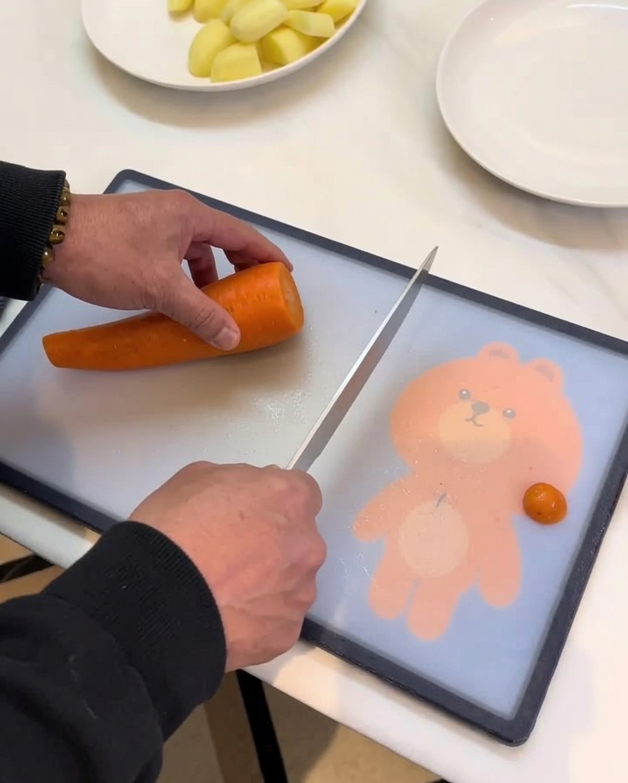Zanahorias, patatas y otras verduras cortadas en trozos sobre una tabla de cortar.