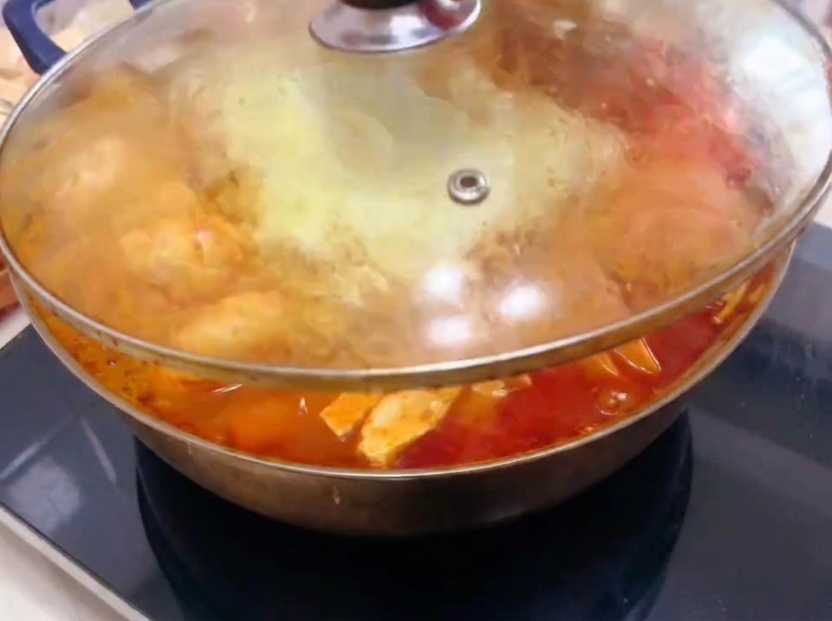 La tapa de vidrio cubriendo la olla mientras la comida se cocina y el caldo burbujea.